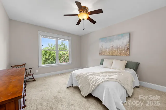 a spacious bedroom with a bed and a chandelier