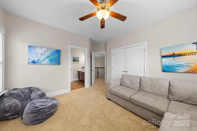 a living room with furniture and a ceiling fan