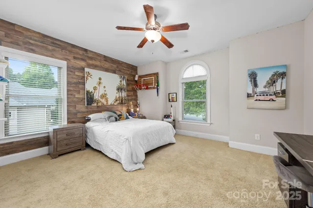 a bedroom with a bed a large window with outer view and couch