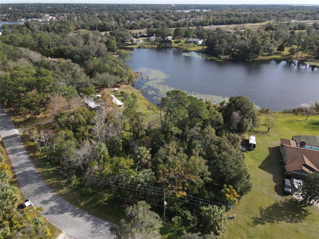 an aerial view of lake residential house with outdoor space and trees around