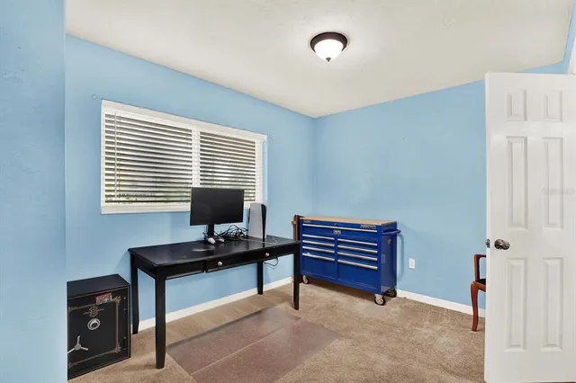 a view of a workspace with furniture and a window