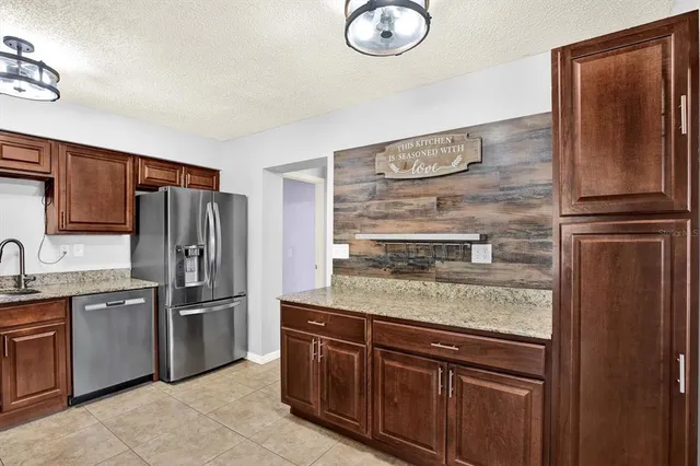 a kitchen with stainless steel appliances granite countertop a refrigerator and a sink