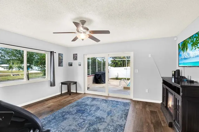 a view of a livingroom with furniture hardwood floor and a ceiling fan