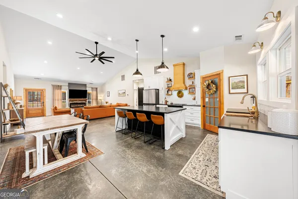 a kitchen with stainless steel appliances granite countertop wooden floor window and refrigerator