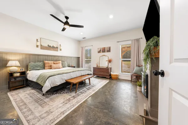 a spacious bedroom with a bed a fireplace and a walk in closet
