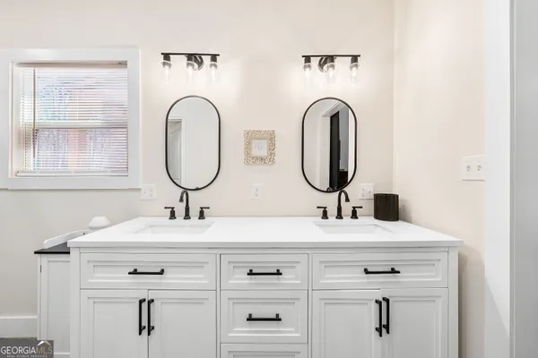 a en suite bathroom with a double vanity sink and a mirror
