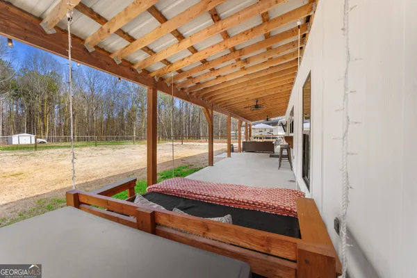 a patio with table and chairs with wooden floor