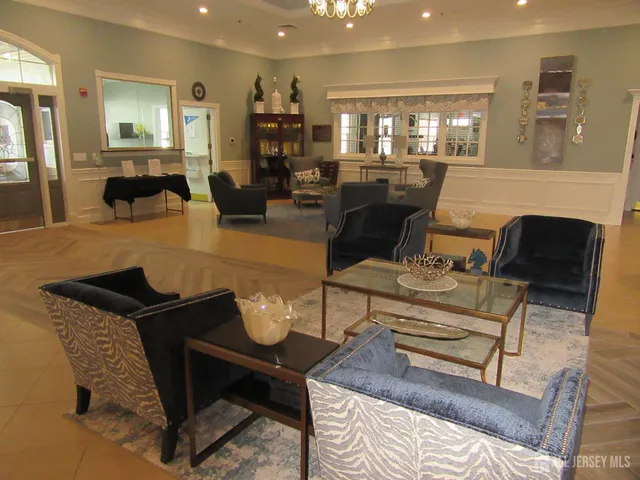 a open kitchen with stainless steel appliances kitchen island granite countertop a table chairs and a refrigerator