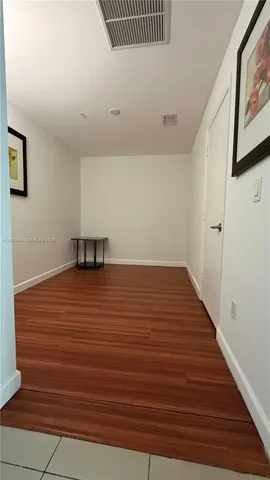 a view of empty room with stairs and wooden floor