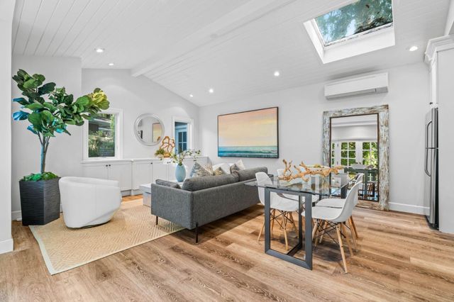 a living room with furniture potted plant and kitchen view