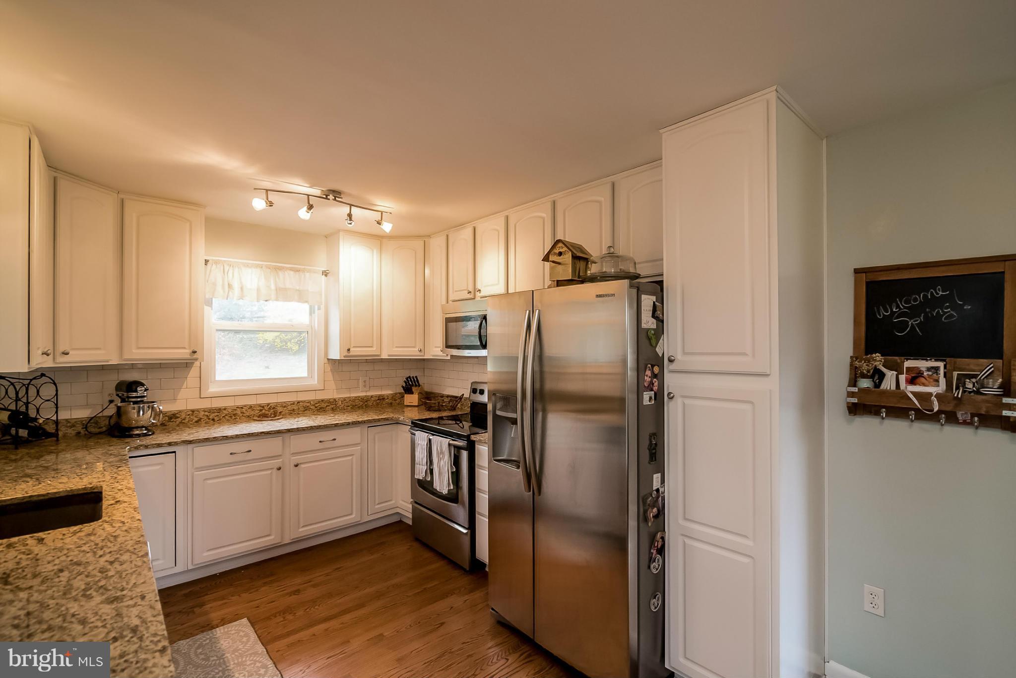 8019 Old Receiver Road Frederick, MD 21702 - Photo 5 of 25 a kitchen with stainless steel appliances granite countertop a refrigerator a sink and white cabinets