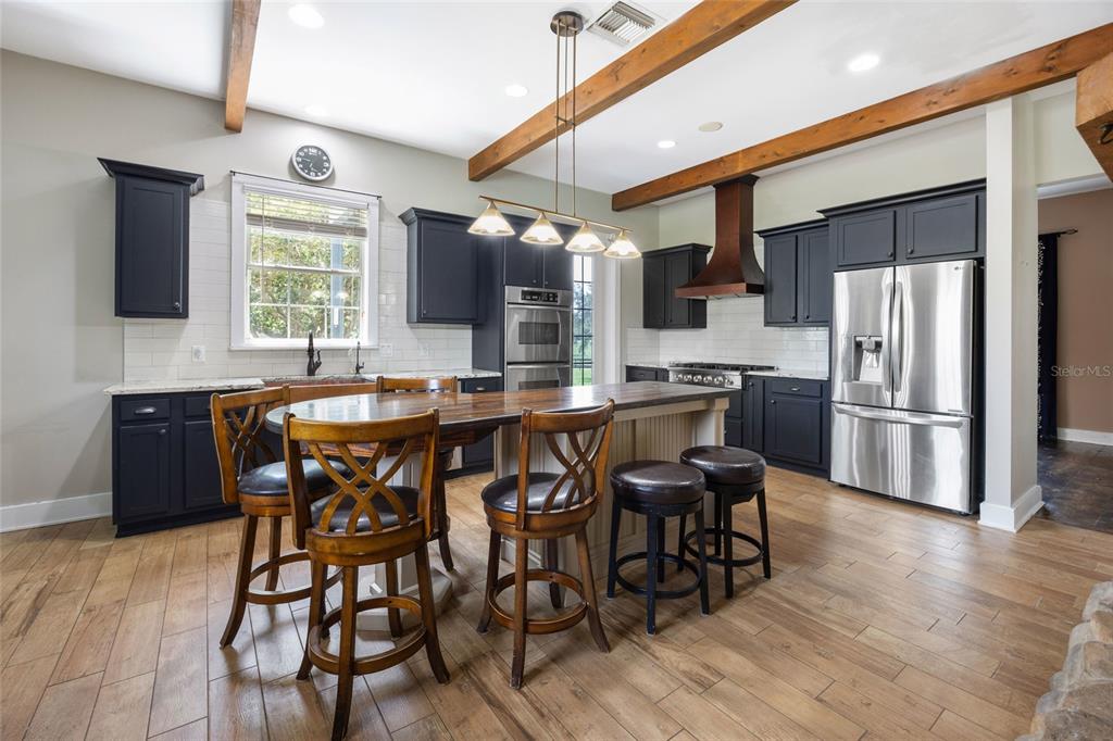 25 Southeast 69th Place Ocala, FL 34480 - Photo 9 of 52 a kitchen with stainless steel appliances a dining table chairs refrigerator and sink