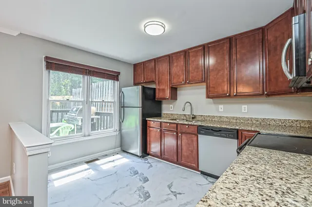 a kitchen with stainless steel appliances granite countertop a refrigerator sink and cabinets