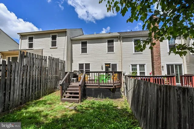 a view of a house with wooden deck and furniture
