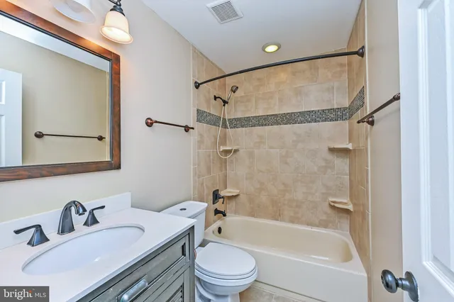 a bathroom with a toilet sink vanity and mirror