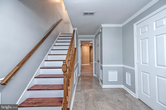 a view of staircase with wooden floor and white walls