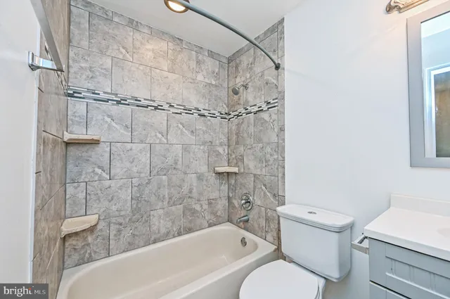 a bathroom with a toilet sink vanity and mirror