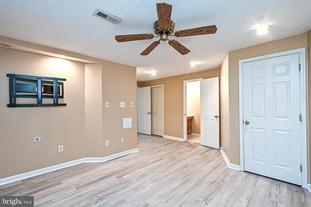a view of an empty room and window and wooden floor