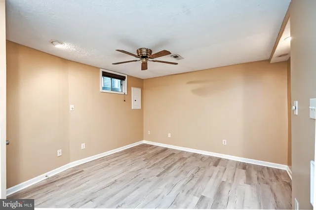 a view of room with wooden floor and ceiling fan