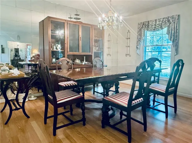 a dining room with furniture a chandelier and wooden floor