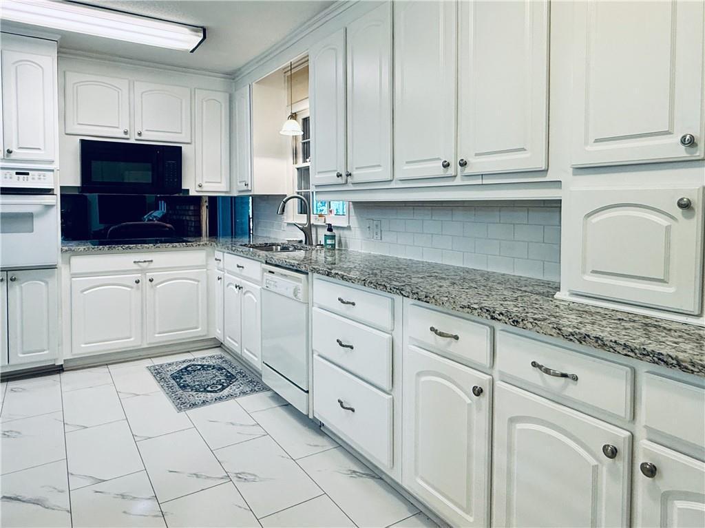 217 Cherokee Circle Cedartown, GA 30125 - Photo 10 of 25 a kitchen with stainless steel appliances granite countertop white cabinets sink and dishwasher