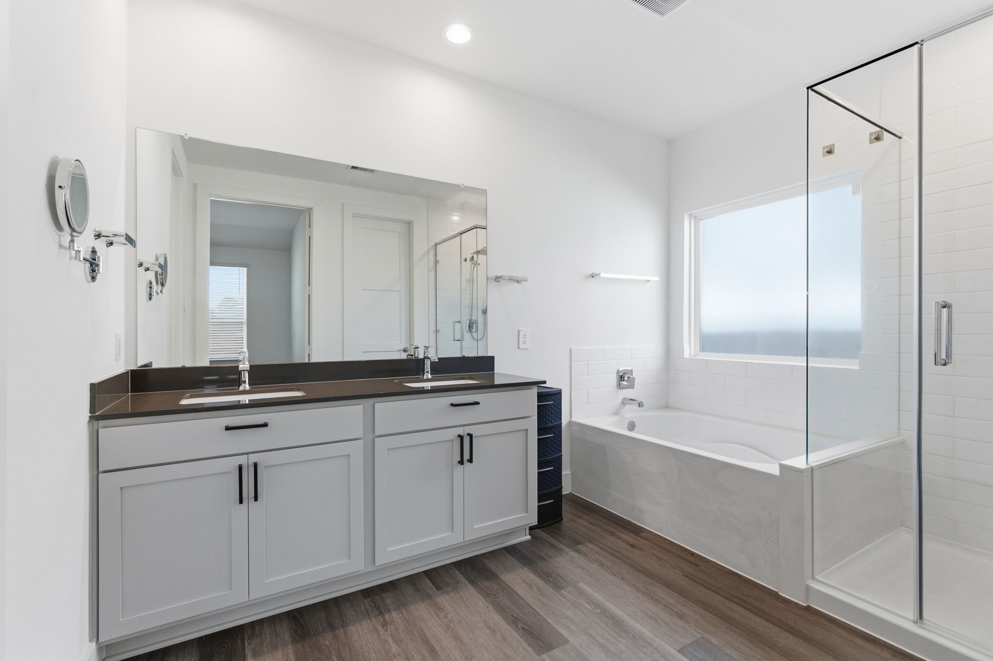 13776 Rising Sun Lane Conroe, TX 77384 - Photo 13 of 30 a bathroom with a double vanity sink and mirror with bathtub