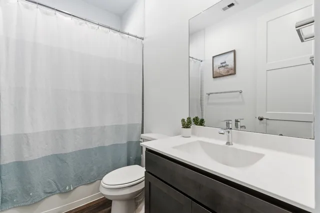 a bathroom with a sink a toilet and a mirror