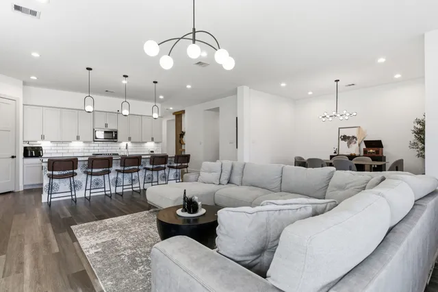a living room with furniture kitchen and a chandelier