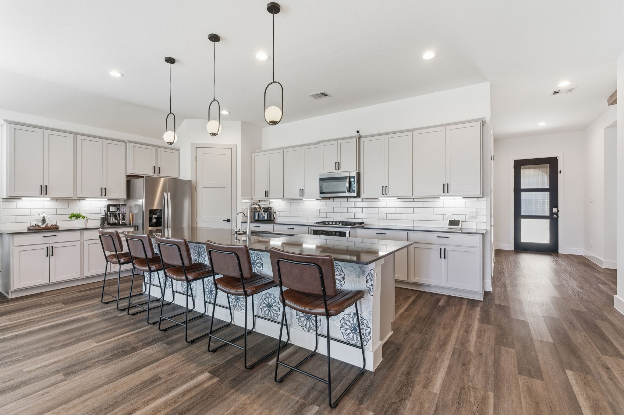 13776 Rising Sun Lane Conroe, TX 77384 - Photo 9 of 30 a kitchen with stainless steel appliances kitchen island granite countertop a wooden floor and white cabinets