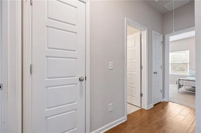 a view of a hallway with bathroom and wooden floor
