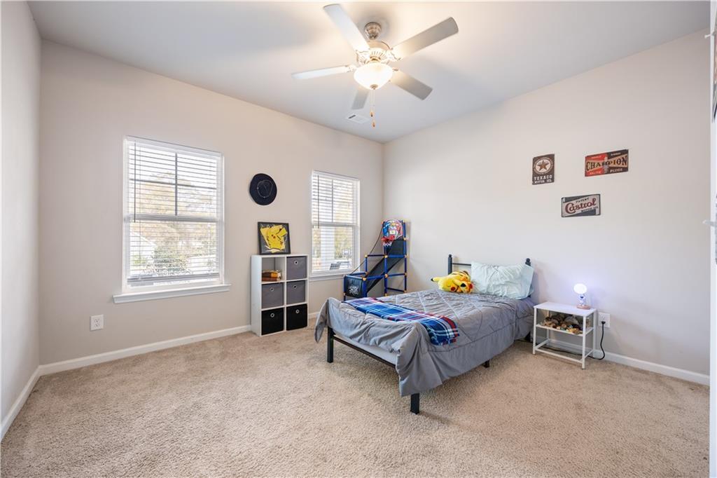 184 Ashford Lane Commerce, GA 30529 - Photo 22 of 49 a bedroom with a bed a chandelier and a window