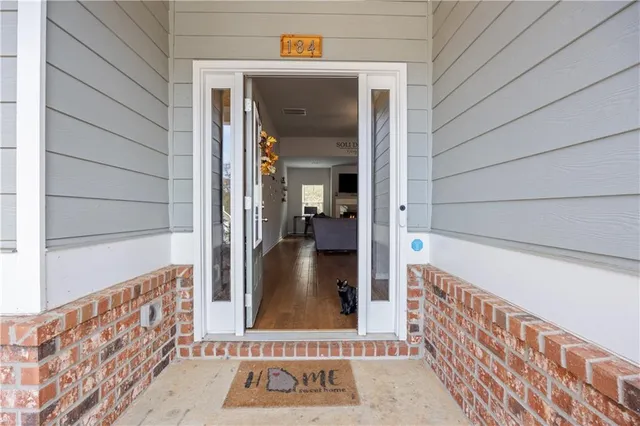 a view of a hallway with wooden floor and a door