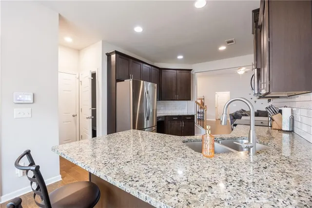 a kitchen with stainless steel appliances kitchen island granite countertop a table and chairs