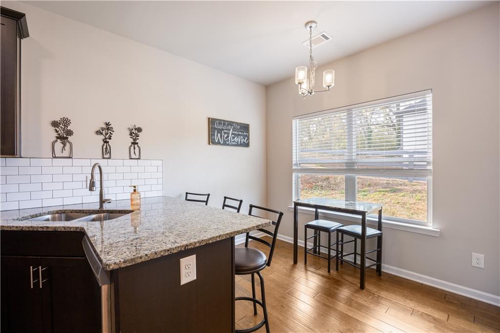 184 Ashford Lane Commerce, GA 30529 - Photo 34 of 49 a kitchen with granite countertop sink table and chairs