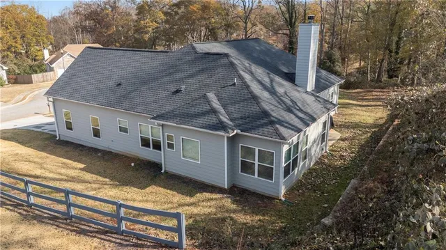 a front view of house with yard and trees in the background