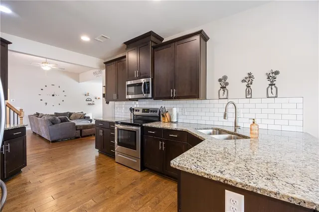 a kitchen with stainless steel appliances granite countertop a sink dishwasher stove and oven