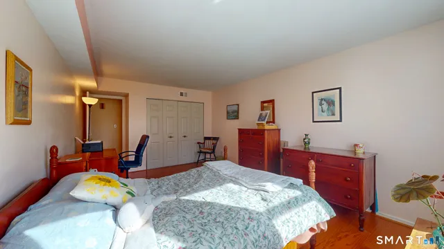 a bedroom with a bed and wooden floor