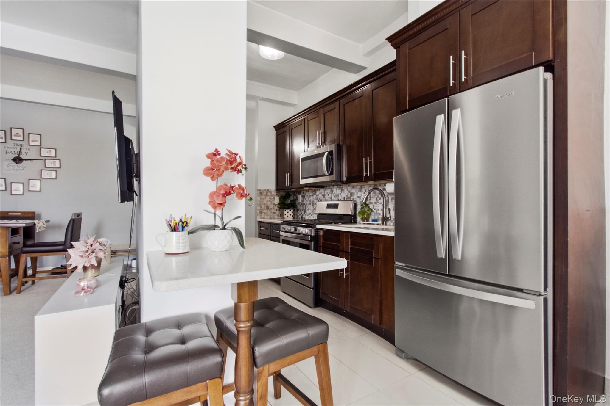 245 Rumsey Road, Unit 2S Yonkers, NY 10701 - Photo 11 of 21 a kitchen with stainless steel appliances a refrigerator sink stove dining table and chairs
