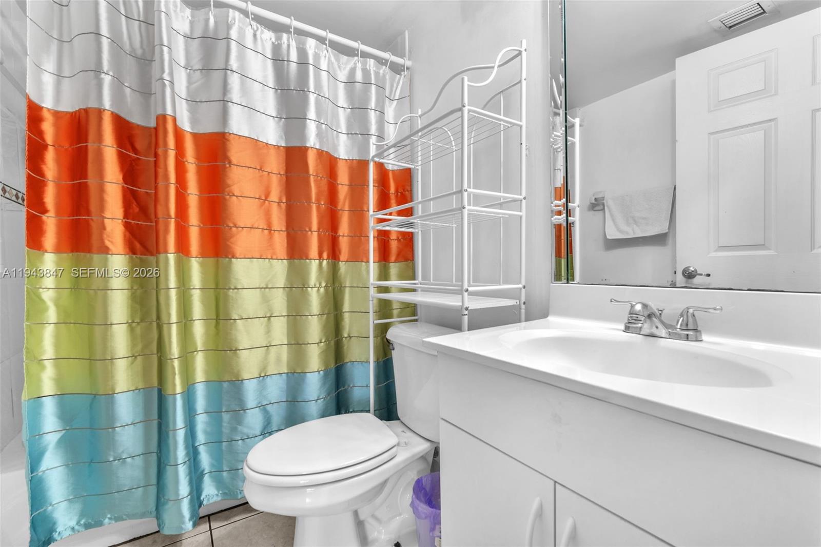 2475 Northwest 16th St Road, Unit 601 Miami, FL 33125 - Photo 11 of 26 a bathroom with a sink a toilet and shower curtain