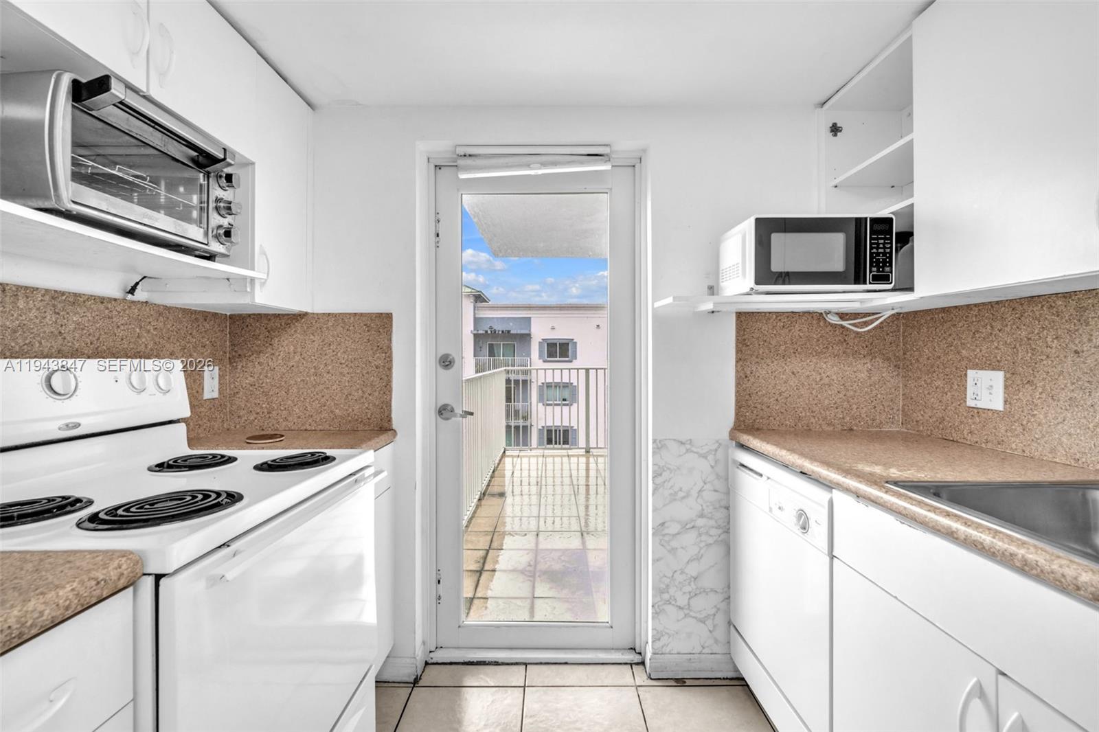 2475 Northwest 16th St Road, Unit 601 Miami, FL 33125 - Photo 18 of 26 a kitchen with stainless steel appliances granite countertop a stove and a microwave