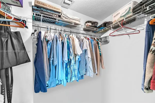 a view of walk in closet with clothes