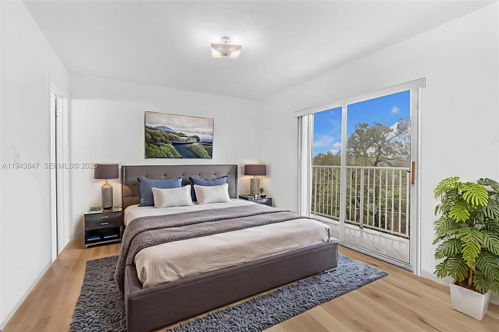 2475 Northwest 16th St Road, Unit 601 Miami, FL 33125 - Photo 7 of 26 a bedroom with a large bed and a painting on the wall