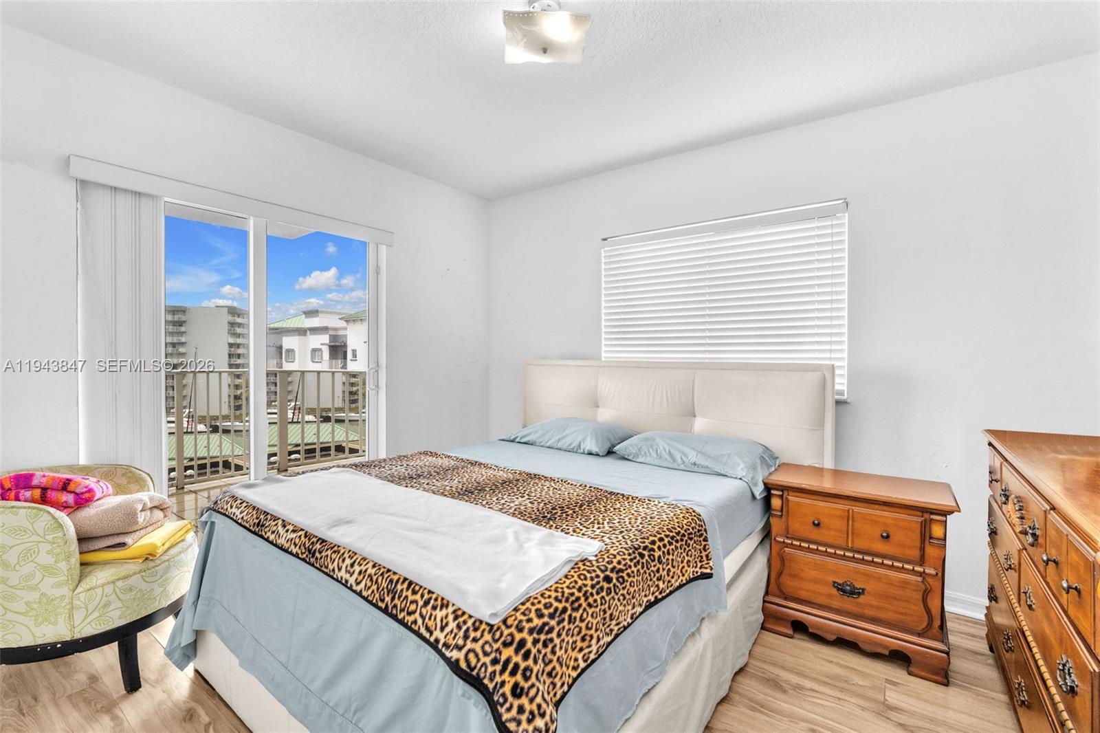 2475 Northwest 16th St Road, Unit 601 Miami, FL 33125 - Photo 9 of 26 a bedroom with a bed and a dresser next to a window