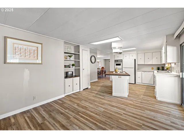 a room with kitchen island stainless steel appliances wooden floor and view living room