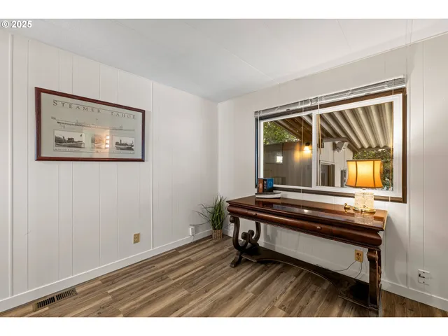 a sitting area with wooden floor next to a window