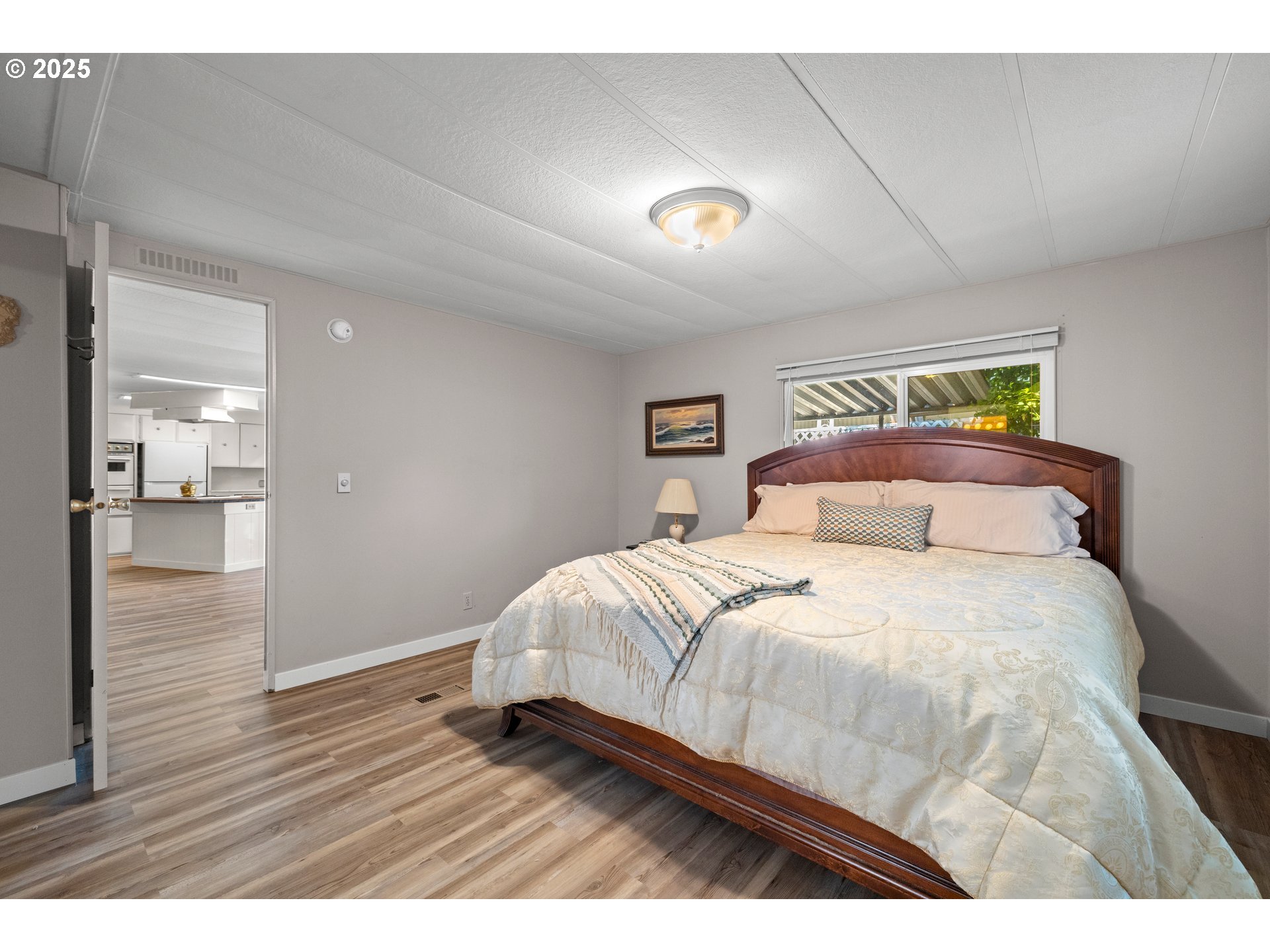 3405 Southeast Vineyard Road, Unit 49 Milwaukie, OR 97267 - Photo 36 of 43 a bedroom with a bed and wooden floor