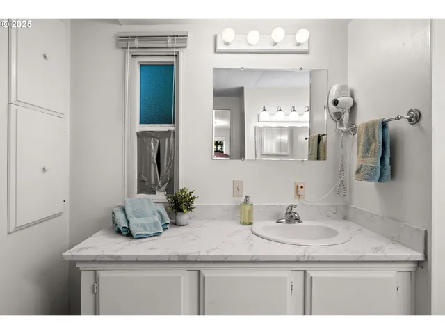 a bathroom with a granite countertop sink and a mirror