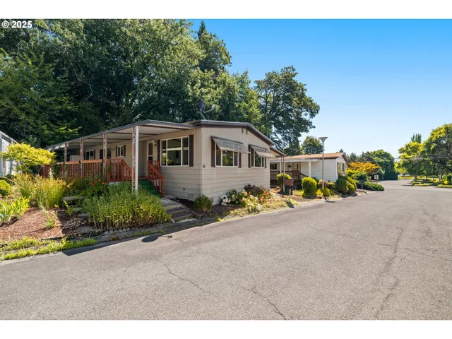 a front view of house with yard and trees in the background