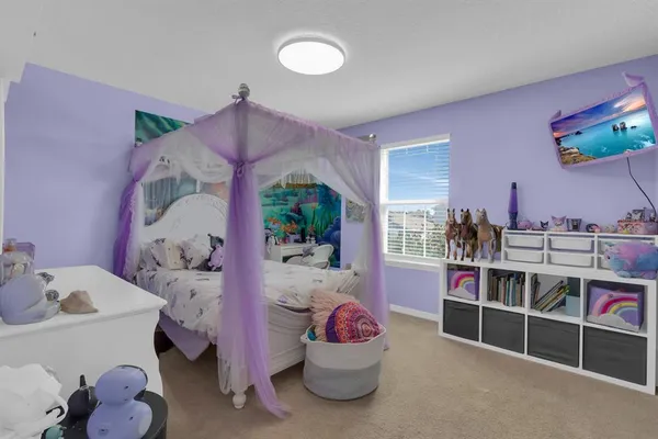 a bedroom with a bed and a flat tv screen on dresser