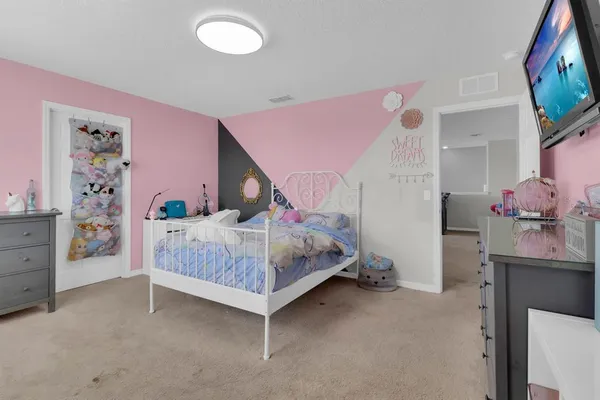 a bedroom with a large bed and a chandelier